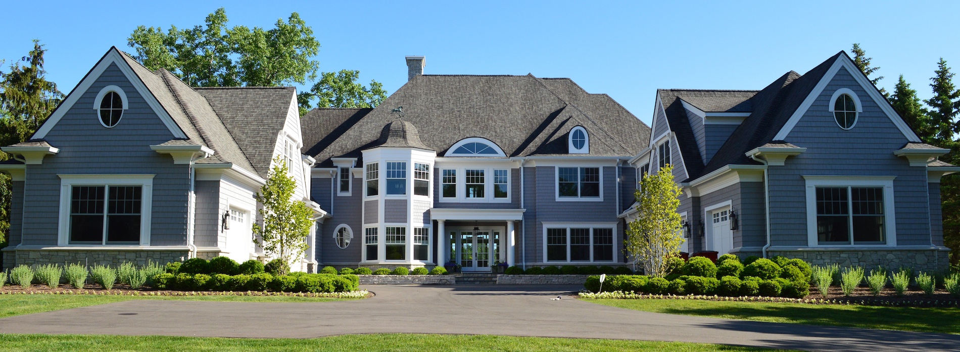 a large brick building with grass in front of a house