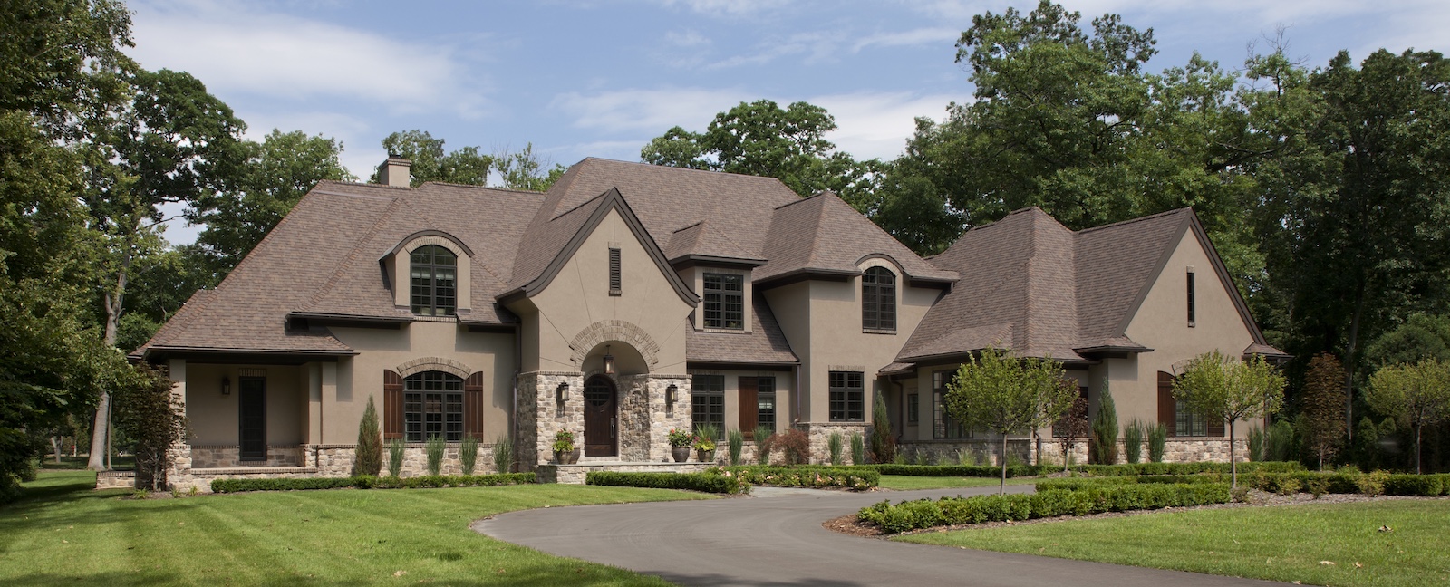 a large brick building with grass in front of a house