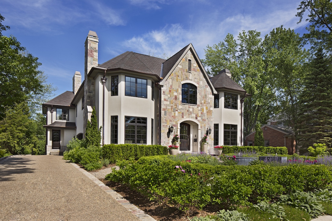 a large brick building with grass in front of a house with President Lincoln's Cottage at the Soldiers' Home in the background